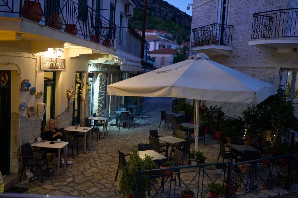 A woman drinks coffee at a snack bar on the island of Kalamos in the Ionian Sea, western Greece, in September. Photo: AP