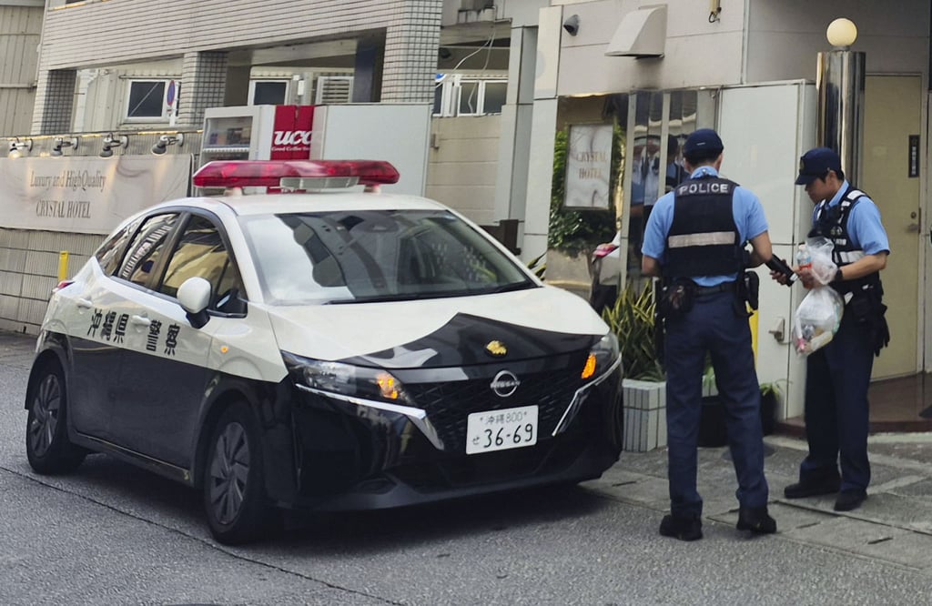 Police officers investigate on Sunday near a hotel where a woman was found dead in Naha, Okinawa. Photo: Kyodo