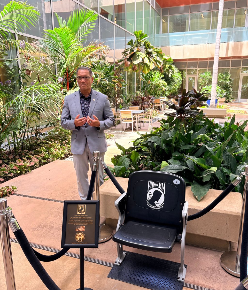 John Figuerres, a senior operations officer at the Defense POW/MIA Accounting Agency, stands beside an empty chair honouring US prisoners of war and those missing in action at the agency’s headquarters in Hawaii. Photo: Teresa Frontado