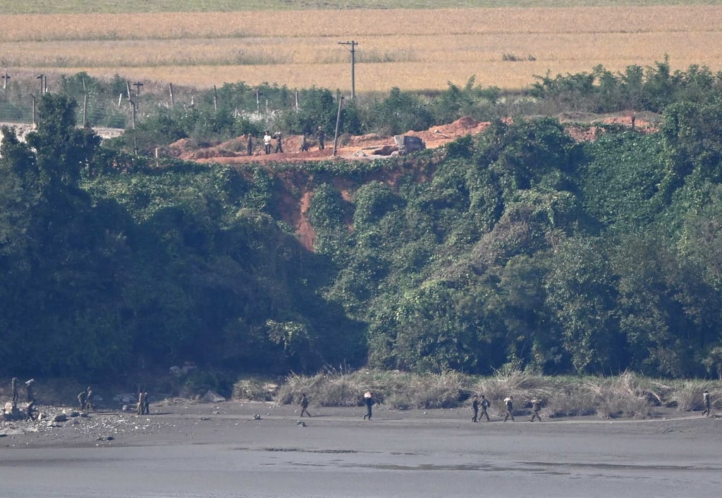 People work near a river on the North Korean side of the DMZ in October 2024, as seen from South Korea’s Odusan Unification Observatory in Paju. Photo: AFP