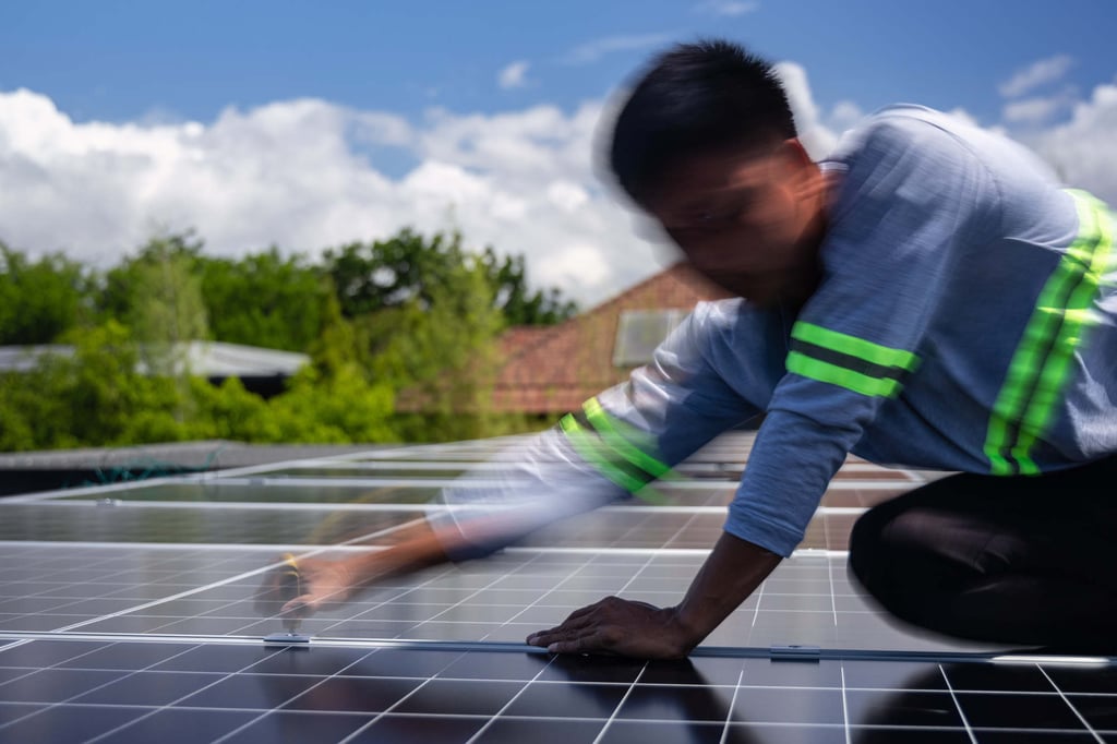 A solar installer secures a solar panel onto the roof of a home in Manila, the Philippines, on May 1. Photo: AP A solar installer secures a solar panel onto the roof of a home in Manila, the Philippines, on May 1. Photo: AP
