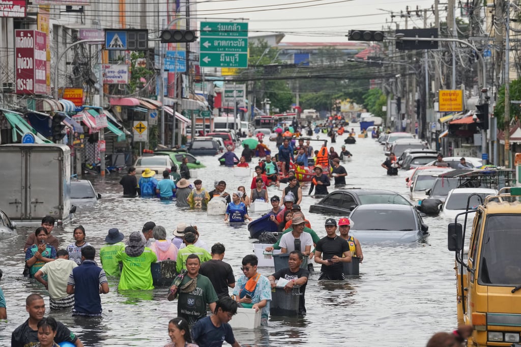 People wade through a flooded street after heavy rain in Bangkok, Thailand, on September 28. Photo: AP People wade through a flooded street after heavy rain in Bangkok, Thailand, on September 28. Photo: AP