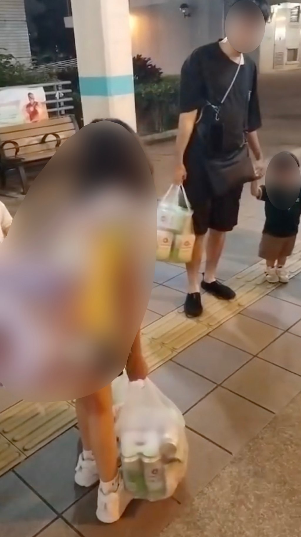 A screenshot from one of the videos posted on social media shows the 10-year-old girl carrying two bags of beer, alongside a man and another child. Photo: Facebook