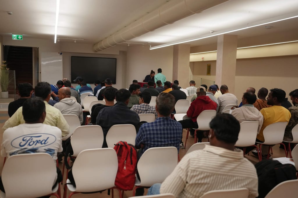 Workers wait their turn to sign an agreement for compensation. Photo: AP