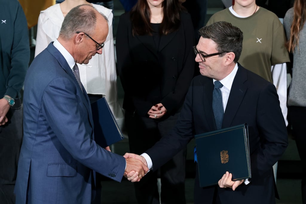 German Chancellor Friedrich Merz (left) and British Prime Minister Andy Burnham exchange ratification documents of the Kensington Treaty at the Chancellery in Berlin on Thursday. Photo: EPA German Chancellor Friedrich Merz (left) and British Prime Minister Andy Burnham exchange ratification documents of the Kensington Treaty at the Chancellery in Berlin on Thursday. Photo: EPA