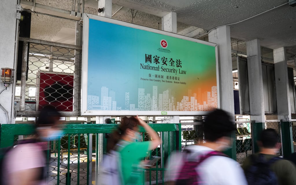 Commuters walk past a large banner promoting the national security law at the Star Ferry Pier in Tsim Sha Tsui. Photo: Sam Tsang
