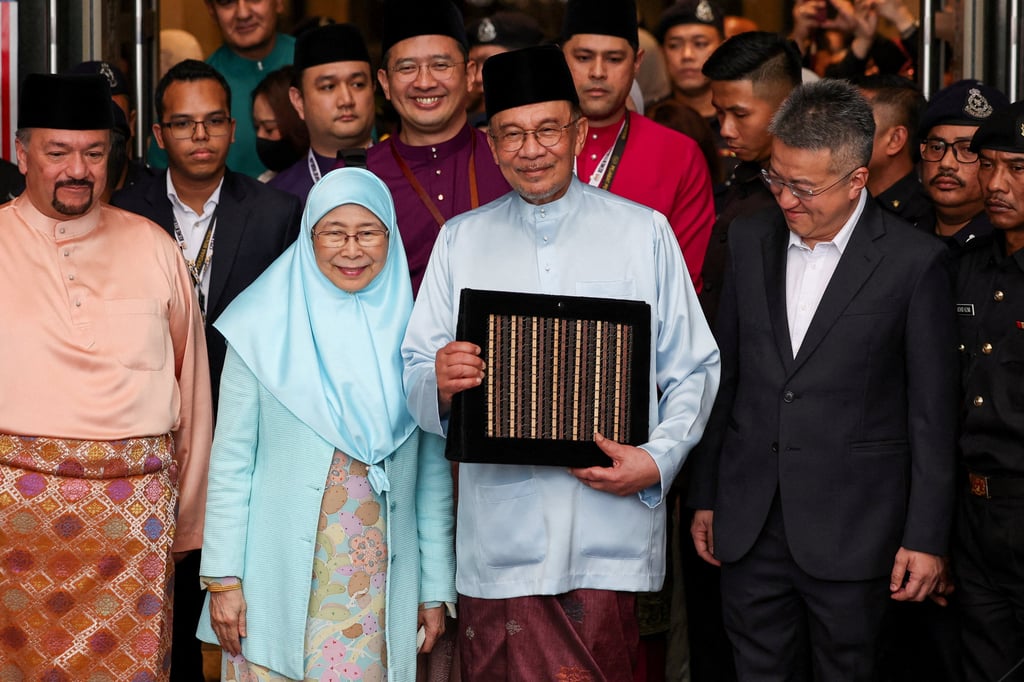 Malaysia’s Prime Minister and Finance Minister Anwar Ibrahim holds the 2027 national budget document at the Finance Ministry building before his budget presentation in parliament on Friday. Photo: Reuters
