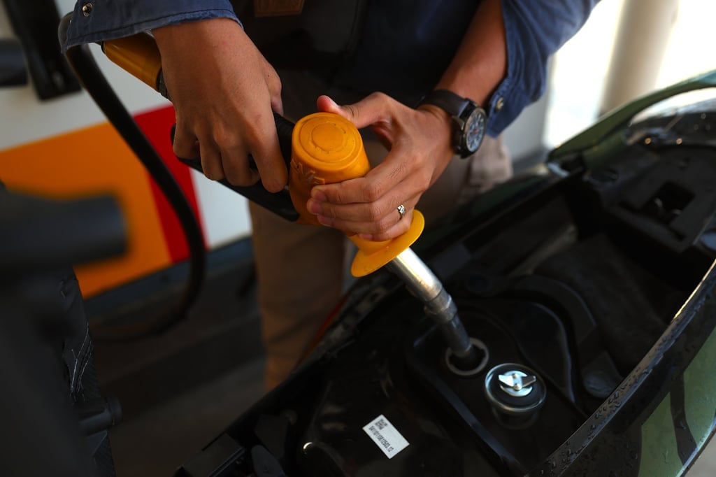 A man fills his motorcycle with petrol at a petrol station in Selangor, Malaysia. Photo: EPA