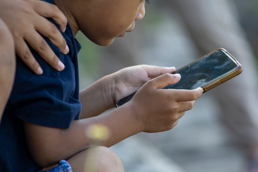 A child uses a mobile phone at a park in Denpasar, Bali, in March. Indonesia’s proposed fine framework for social media companies has yet to be legally codified. Photo: EPA A child uses a mobile phone at a park in Denpasar, Bali, in March. Indonesia’s proposed fine framework for social media companies has yet to be legally codified. Photo: EPA