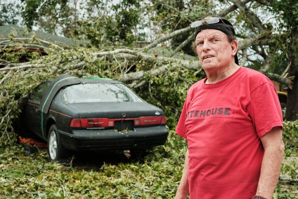 J.J. McDonald stands in front of his car after a tree fell on it following the landfall of Hurricane Isaias in Milton, Florida, on Saturday. Photo: EPA J.J. McDonald stands in front of his car after a tree fell on it following the landfall of Hurricane Isaias in Milton, Florida, on Saturday. Photo: EPA