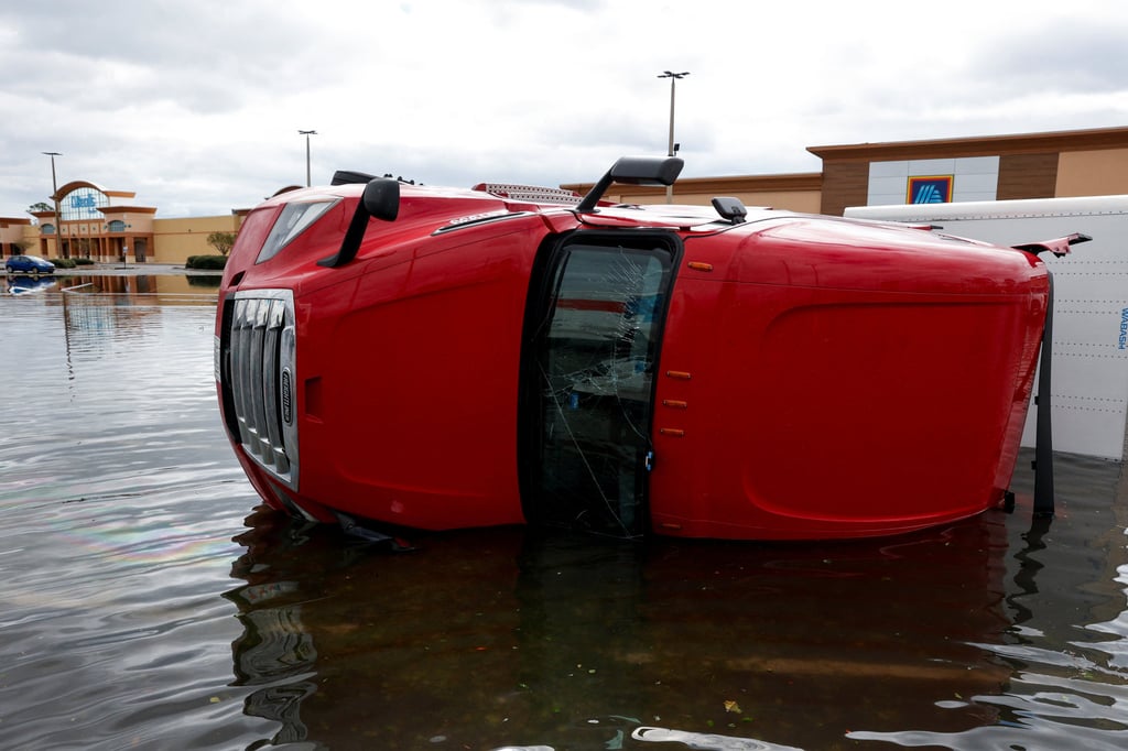 An overturned truck is seen at a partially flooded car park in Gulf Breeze, Florida, on Saturday. Photo: Reuters An overturned truck is seen at a partially flooded car park in Gulf Breeze, Florida, on Saturday. Photo: Reuters
