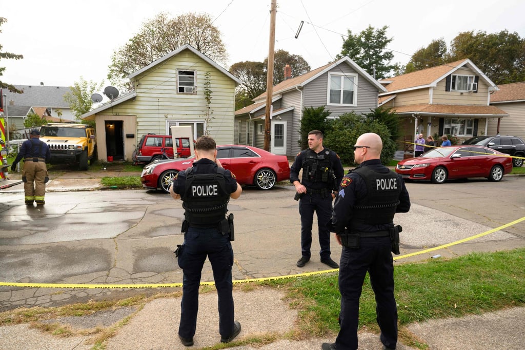 Police officers stand outside a home on Saturday where nine members of a family were found dead in Erie, Pennsylvania. Photo: AFP Police officers stand outside a home on Saturday where nine members of a family were found dead in Erie, Pennsylvania. Photo: AFP