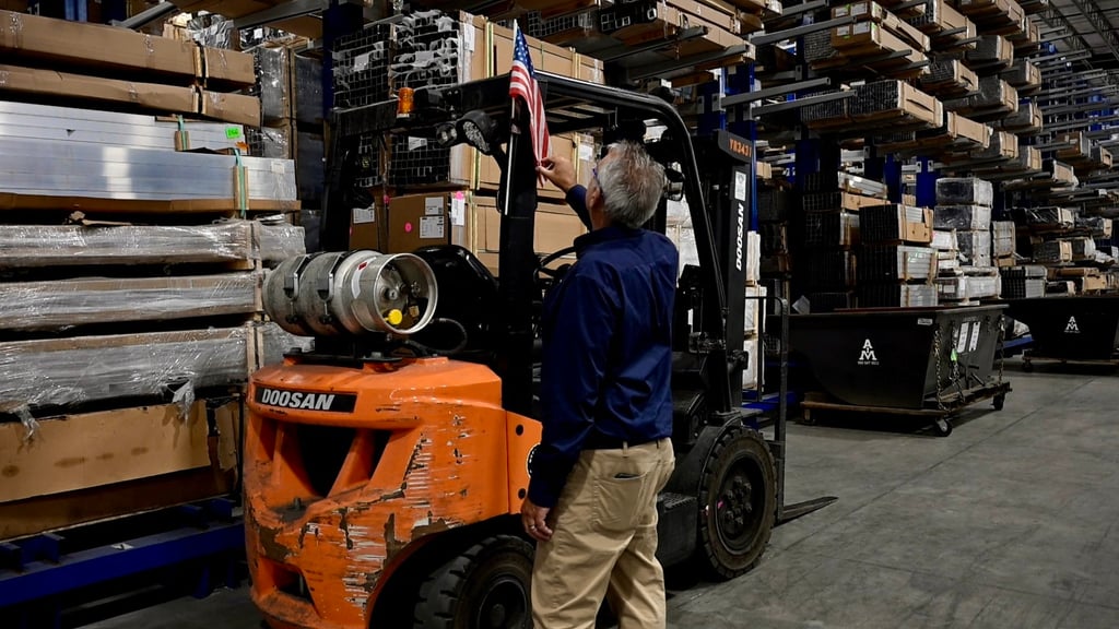 A worker adjusts a US flag attached to a forklift at a warehouse in North Jackson, Ohio, on September 30. Photo: AFP A worker adjusts a US flag attached to a forklift at a warehouse in North Jackson, Ohio, on September 30. Photo: AFP