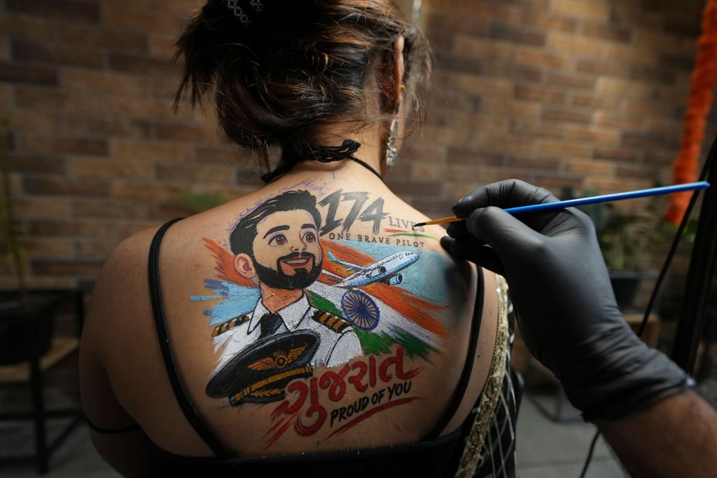 An Indian woman gets a temporary tattoo depicting Indian Flydubai pilot Smit Machchhar on her back in Ahmedabad, India, on Thursday. Photo: AP
