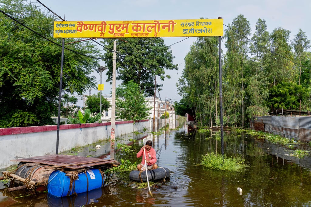 A resident navigates a makeshift raft to reach home as water from the overflowing River Gomti floods a residential area in Lucknow, India, on Friday. Photo: AP