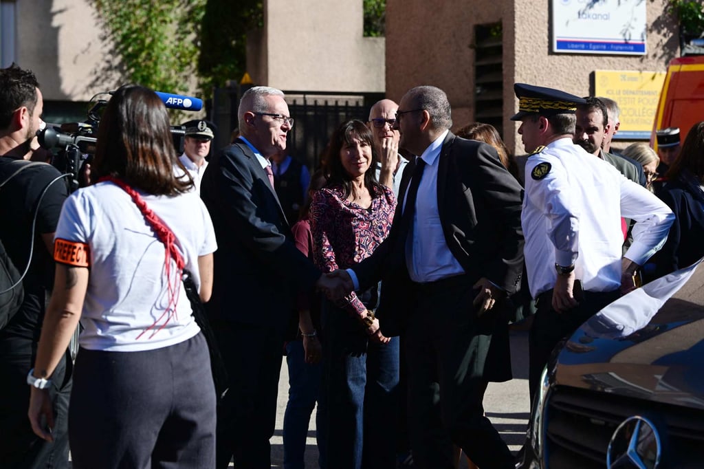 France’s Interior Minister Laurent Nunez (centre, right) is welcomed upon his arrival to Joseph-Lakanal Middle School a few hours after teachers there were wounded in a shooting. Photo: AFP