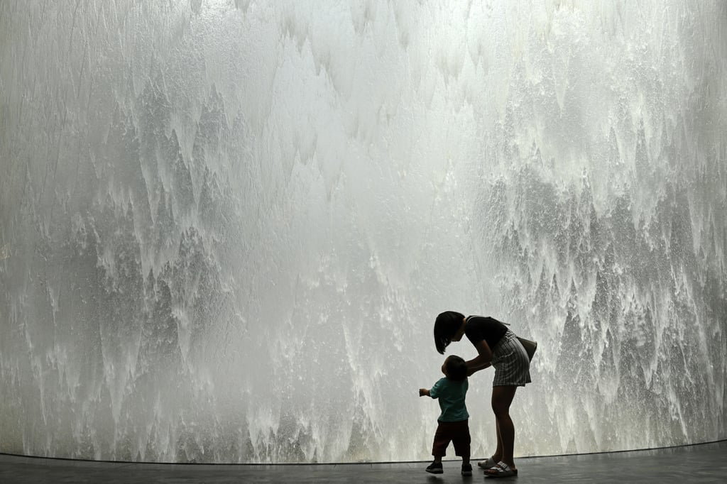 A mother and her child stand next to the Rain Vortex display at Jewel Changi Airport in Singapore. The city state’s fertility rate sank to a low of 0.87 last year. Photo: AFP A mother and her child stand next to the Rain Vortex display at Jewel Changi Airport in Singapore. The city state’s fertility rate sank to a low of 0.87 last year. Photo: AFP