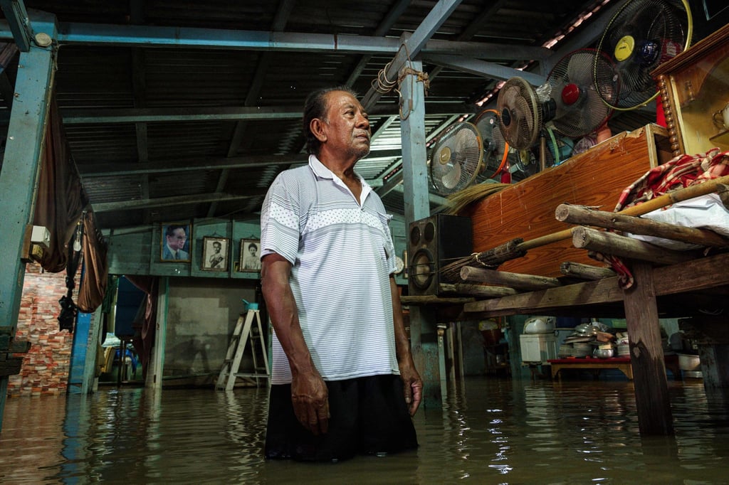 Thai retiree Sommai Kitklin, 63, stands inside his flooded home in the Sena district of Ayutthaya province on October 7. Photo: AFP