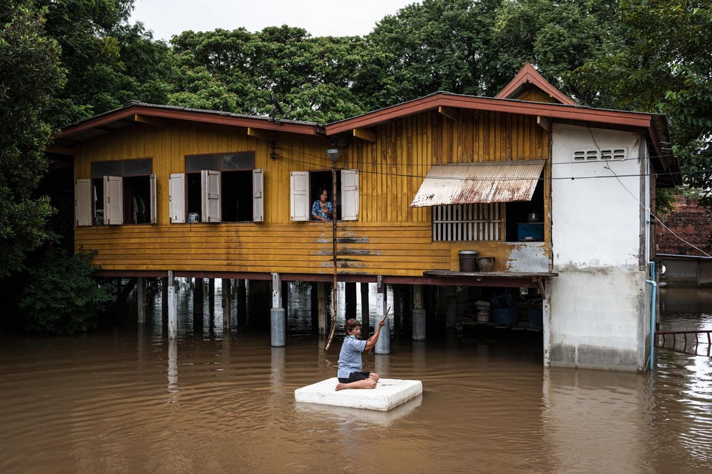 A villager paddles a foam float past a flooded home in the central Thai province of Ayutthaya on October 6. Photo: AFP