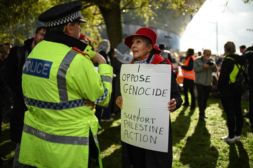 A policeman speaks to a supporter of Palestine Action as people gather to protest in Liverpool, England, in September. Photo: AFP