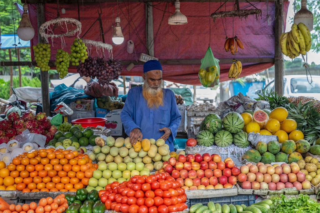 A shopkeeper arranges fruits at a market in Bangladesh’s Pabna district last month. The IMF has forecast inflation to rise next year to 10.9 per cent. Photo: AFP A shopkeeper arranges fruits at a market in Bangladesh’s Pabna district last month. The IMF has forecast inflation to rise next year to 10.9 per cent. Photo: AFP