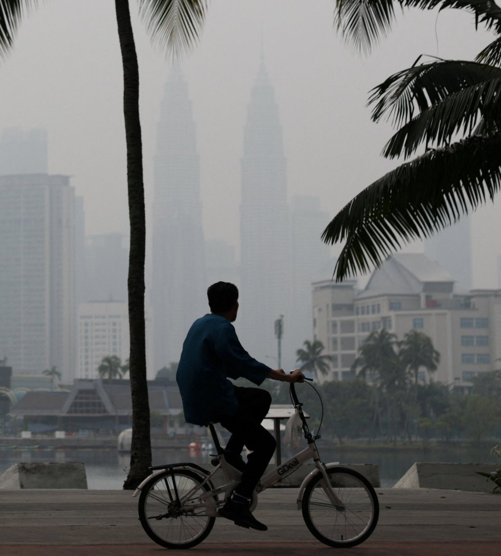 A man cycles with Kuala Lumpur’s skyline in the background shrouded in haze from regional wildfires on Thursday. Photo: Reuters A man cycles with Kuala Lumpur’s skyline in the background shrouded in haze from regional wildfires on Thursday. Photo: Reuters
