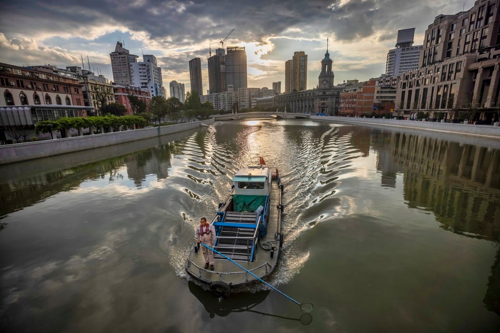 A man cleans a canal in Shanghai in September 2020. China’s Communist Party wrote “ecological civilisation” into its constitution in 2012. Photo: EPA-EFE A man cleans a canal in Shanghai in September 2020. China’s Communist Party wrote “ecological civilisation” into its constitution in 2012. Photo: EPA-EFE