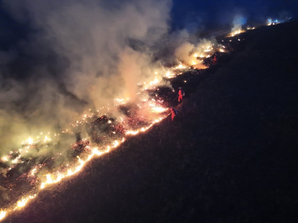 An aerial drone photo shows firefighters extinguishing a grassland fire at the border area in northern China’s Inner Mongolia autonomous region. Photo: Xinhua