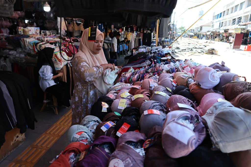 Customers shop for clothes at a clothes market in Banda Aceh, Indonesia, on October 1. Photo: EPA