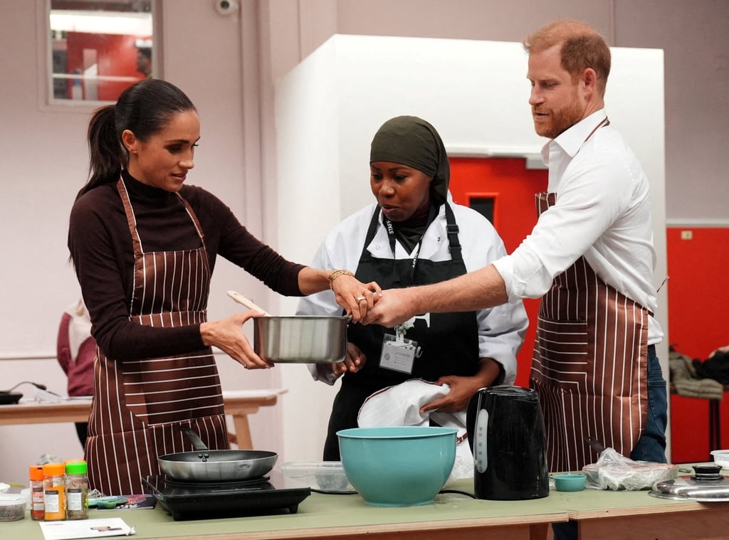 Prince Harry and Meghan cook during a visit to Himmah Hub in Nottingham on Thursday. Photo: Reuters Prince Harry and Meghan cook during a visit to Himmah Hub in Nottingham on Thursday. Photo: Reuters
