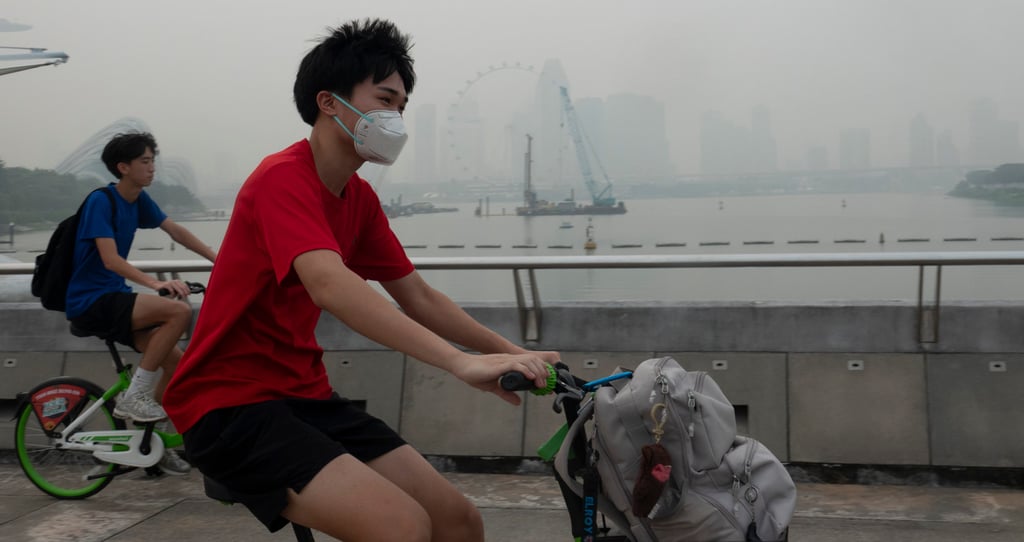 People ride amid the haze at the Marina Bay area in Singapore on Thursday. Photo: Xinhua People ride amid the haze at the Marina Bay area in Singapore on Thursday. Photo: Xinhua