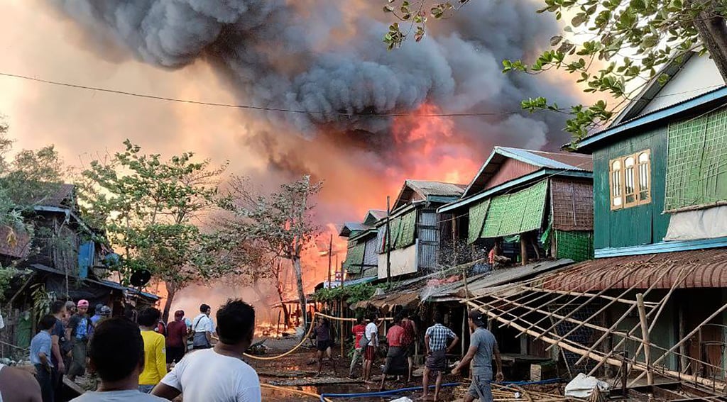 People douse flames rising after an air strike by Myanmar’s military in Kyauk Ni Maw village, Rakhine state, last year. Photo: Arakan Army via AP