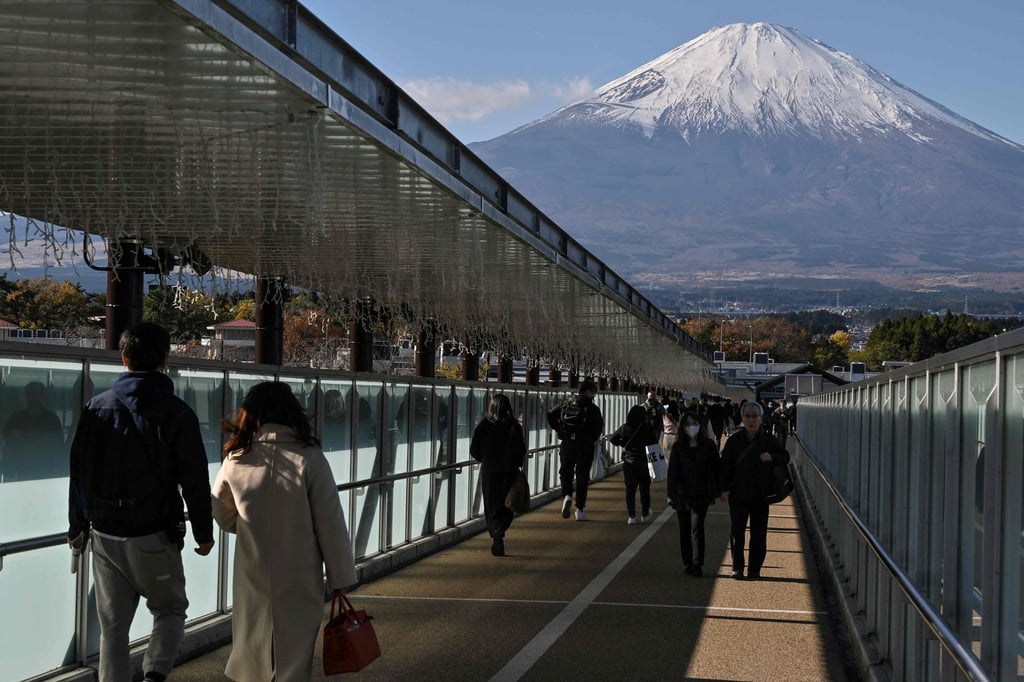 Mount Fuji pictured in the background as people walk along a bridge in Gotemba, Shizuoka. A Japanese airline crew member says her peers prefer to serve passengers flying domestic routes. Photo: AFP Mount Fuji pictured in the background as people walk along a bridge in Gotemba, Shizuoka. A Japanese airline crew member says her peers prefer to serve passengers flying domestic routes. Photo: AFP