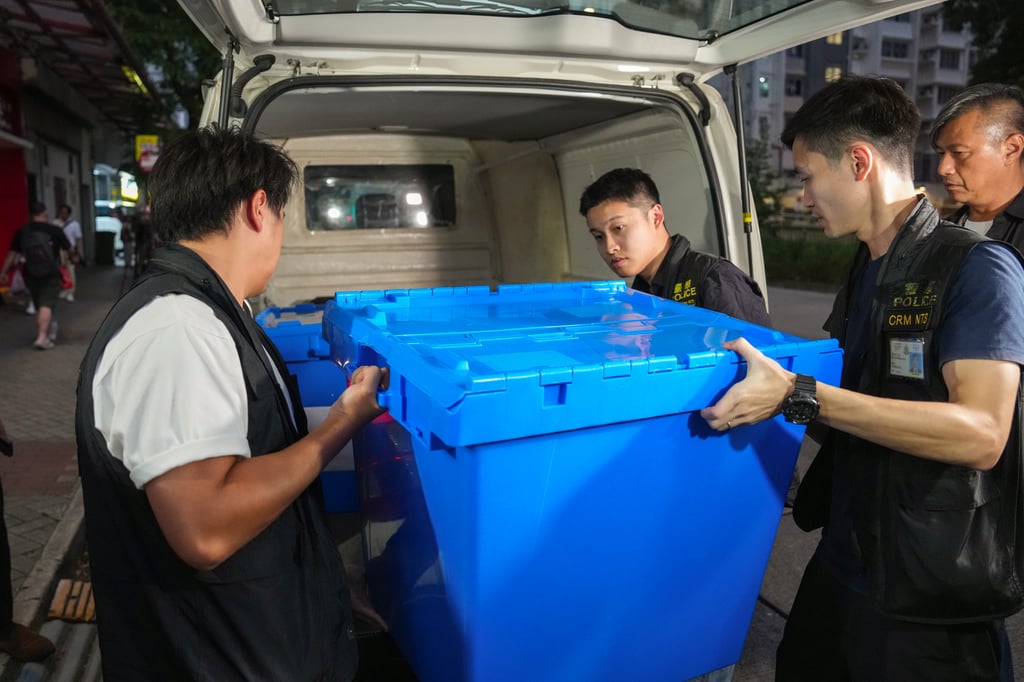 Police officers seize evidence from an office in Chai Wan as part of the lift investigation. Photo: Kit Lai Police officers seize evidence from an office in Chai Wan as part of the lift investigation. Photo: Kit Lai