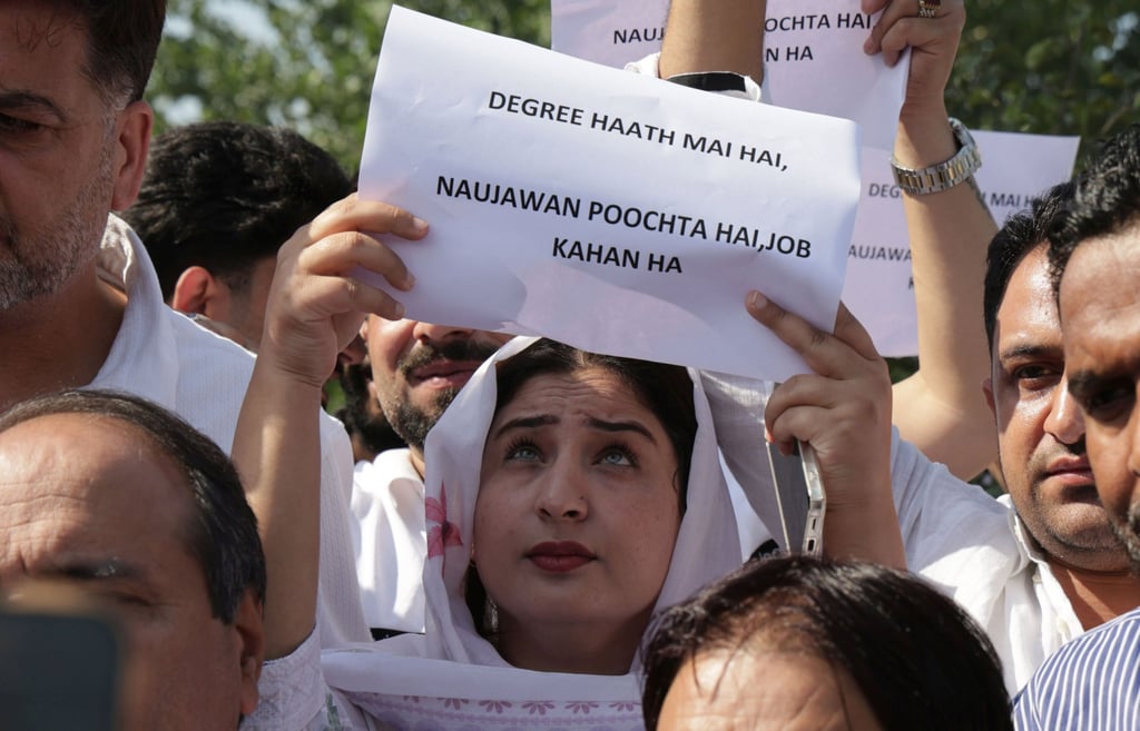 A woman holds a placard reading “Degrees are in hand, but the youth are asking, ‘Where are the jobs?’” during a protest in Srinagar, Indian Kashmir, on September 21. Photo: EPA