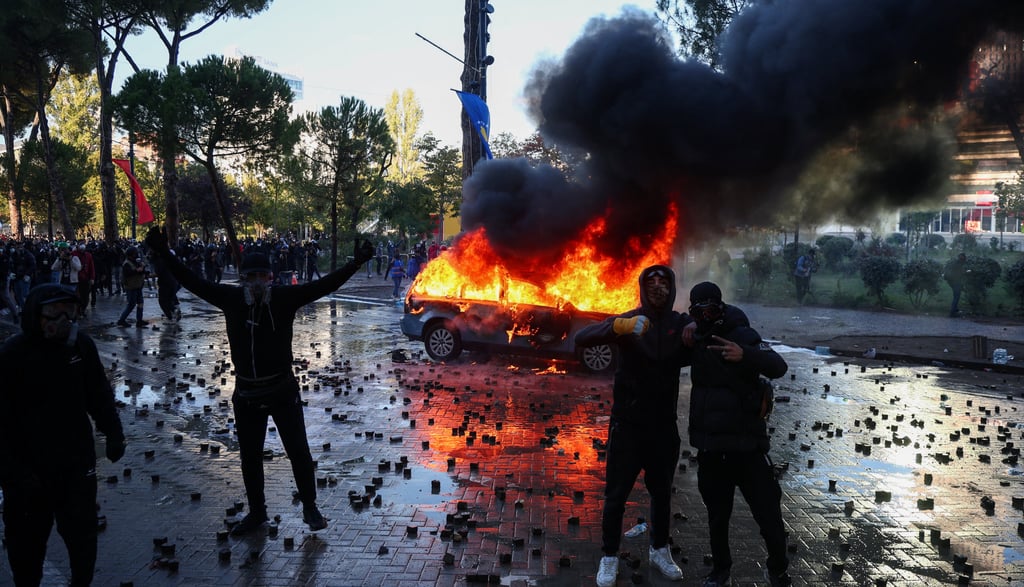 Protesters stand near a burning car during an anti-government protest by students in Tirana, Albania, October 17, 2026. REUTERS/Florion Goga