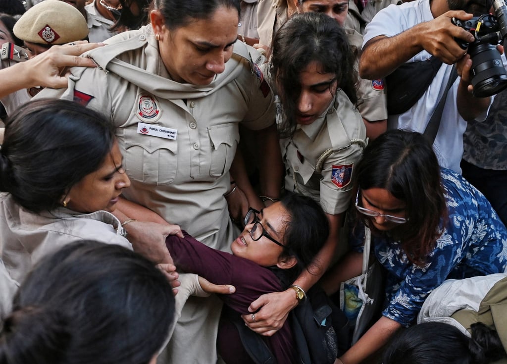 Prominent student leader Neha Bora (centre) is detained by the police during a youth demonstration in Delhi on Friday. Photo: AP
