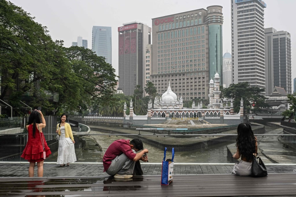 People take photos in front of the Masjid Jamek Sultan Abdul Samad mosque in Kuala Lumpur on Sunday, as Malaysia continues to be shrouded in haze caused by fires in Indonesia. Photo: AFP