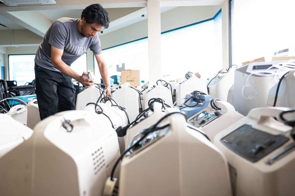 A technician inspects oxygen concentrators awaiting repair and cleaning at a warehouse in Kuala Lumpur on Thursday. Photo: AFP