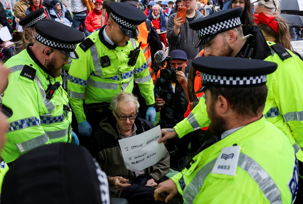 Police officers grab a sign held by a campaigner of Palestine Action as they remove him amid a protest outside the venue of the Labour Party’s annual conference in Liverpool on September 27. Photo: Reuters Police officers grab a sign held by a campaigner of Palestine Action as they remove him amid a protest outside the venue of the Labour Party’s annual conference in Liverpool on September 27. Photo: Reuters