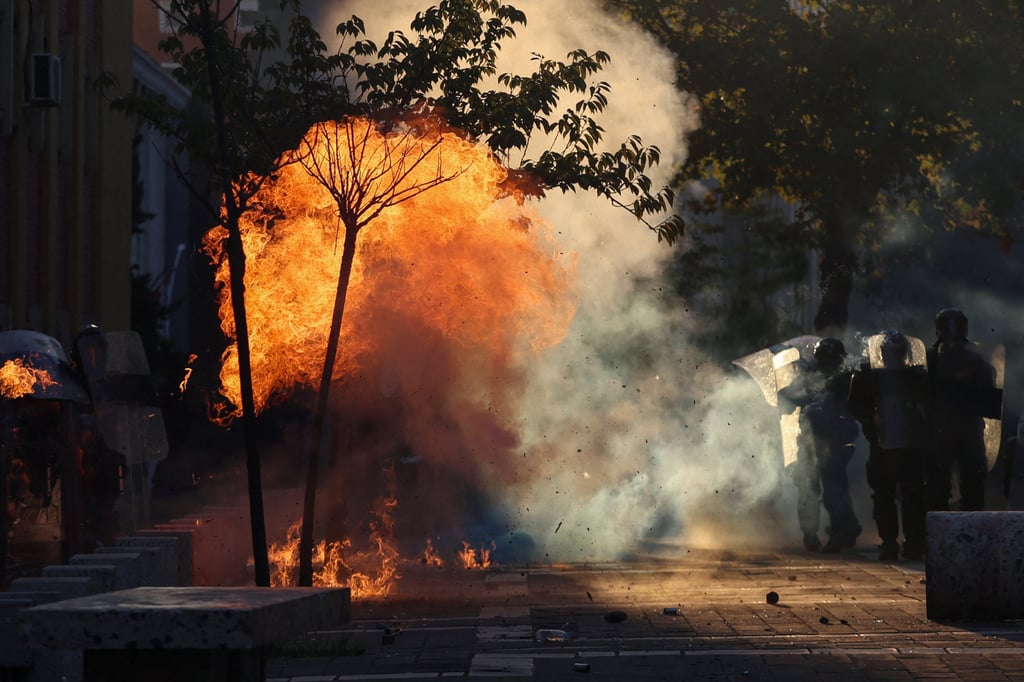 A Molotov cocktail explodes near police during an anti-government protest by students in Tirana, Albania on Sunday. Photo: Reuters