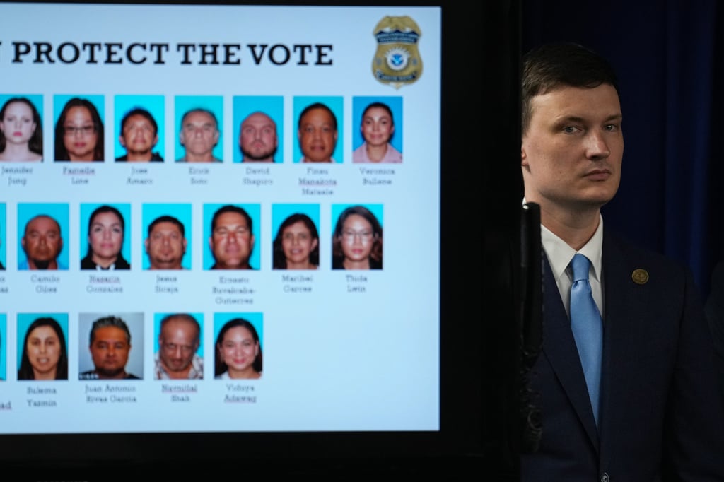 Acting US Deputy Attorney General Trent McCotter stands next to a display showing photos of people charged with illegally registering to vote during a news conference in Los Angeles, California on Monday. Photo: AP