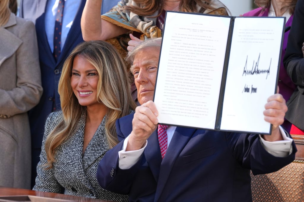 Trump holds up a signed executive order alongside his wife Melania Trump in the Rose Garden of the White House on Monday. Photo: AP