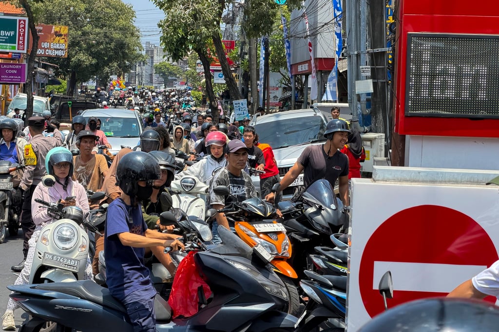 Motorcyclists queue to refuel at a petrol station on Tuesday in Denpasar, Bali. Photo: EPA