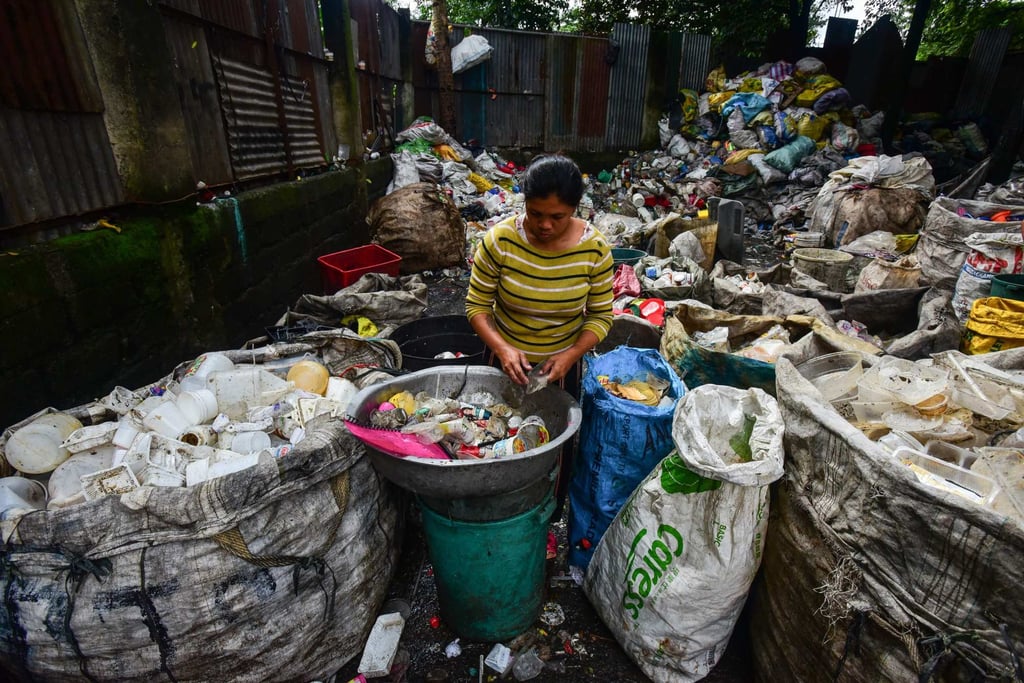 A woman sorts plastic items from piles of trash to be sold at recycling shops in Manila, the Philippines. Junkyards have been a source of income for urban poor who live in communities near city dumpsites. Photo: AFP