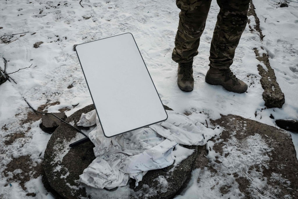 A Ukrainian serviceman stands next to the antenna of a Starlink satellite-based broadband system in Bakhmut in February 2023. Photo: AFP