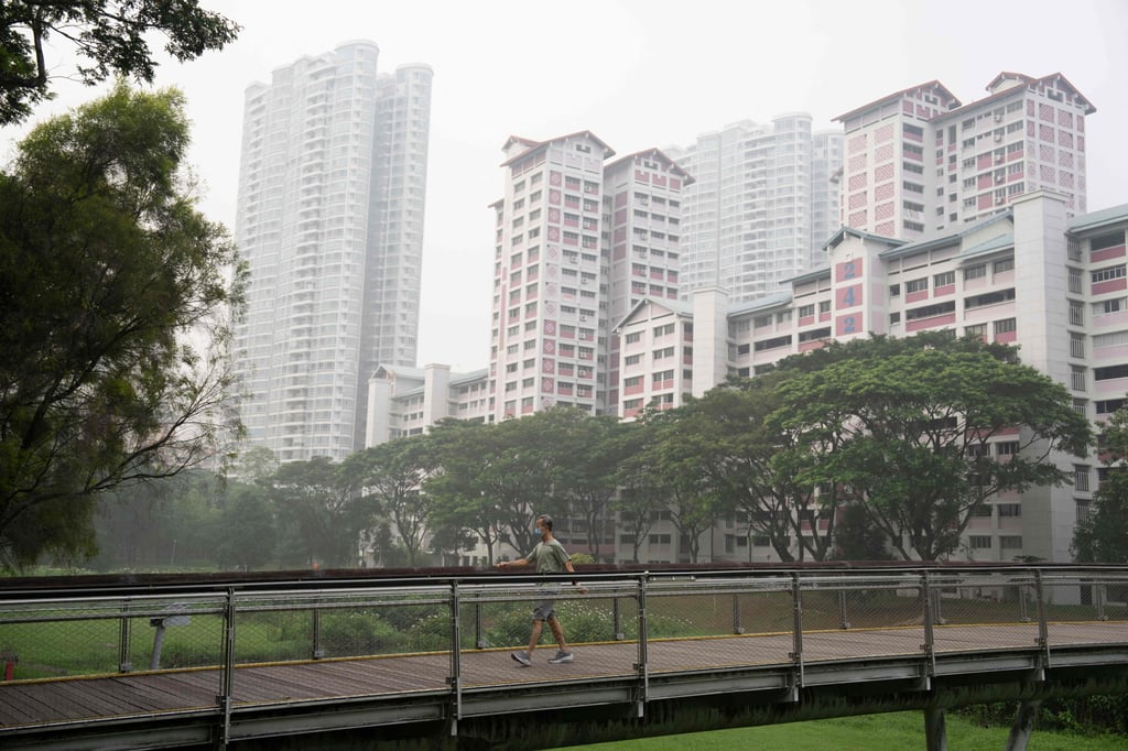 A man wearing a face mask walks past public housing buildings in Singapore on Saturday, as the country continues to be shrouded in haze caused by fires in Indonesia. Photo: AFP