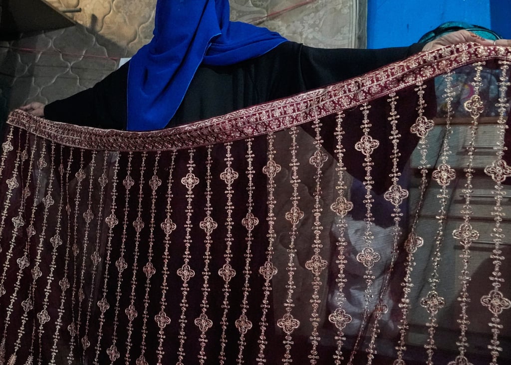 Siddiqui shows embroidery work that she does for extra income in Karachi on October 4. Photo: AP