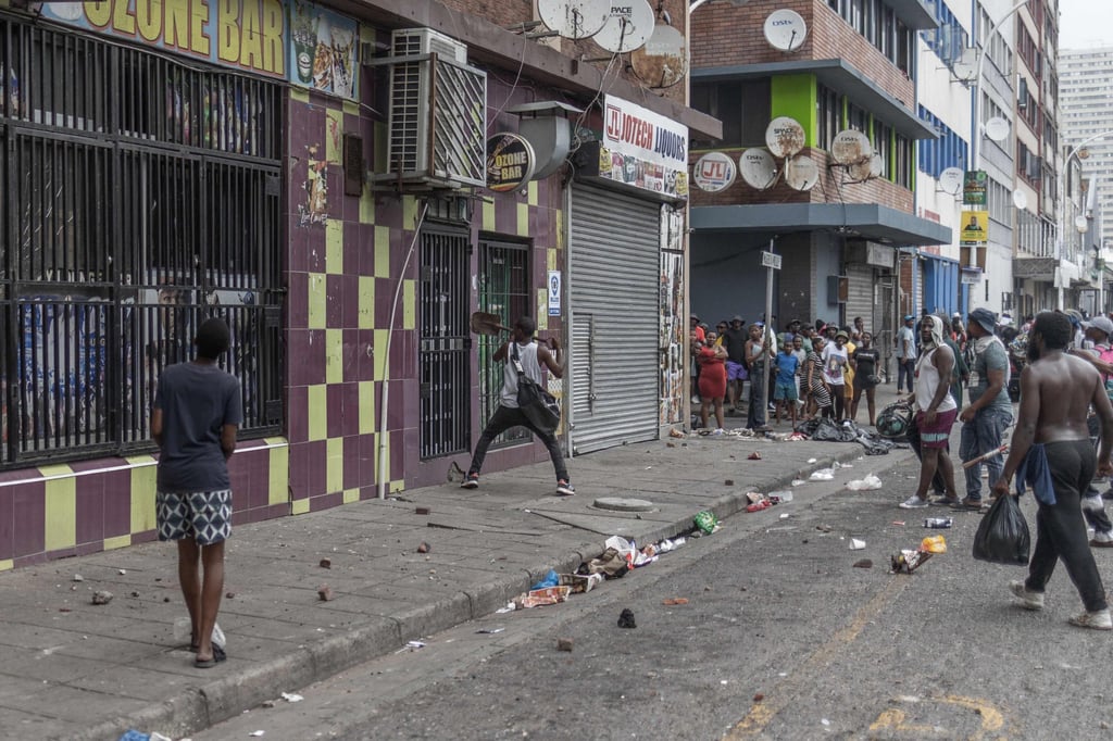 A protester uses a spade to open a gate of a building during a march in Durban on October 9. Photo: AFP A protester uses a spade to open a gate of a building during a march in Durban on October 9. Photo: AFP