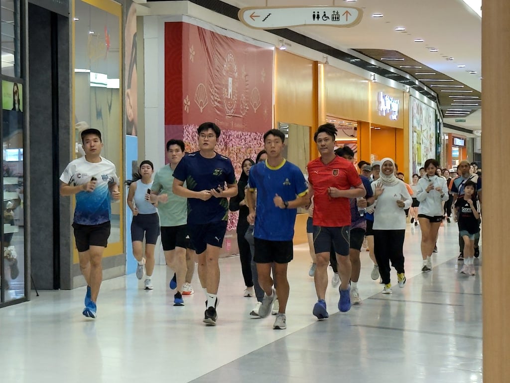 Runners make their way past shopfronts at Atria Shopping Gallery in Petaling Jaya, Malaysia, on Wednesday, as worsening haze drives fitness enthusiasts indoors. Photo: Iman Muttaqin Yusof